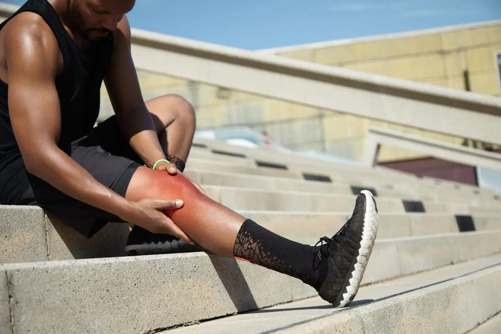 Deportista sujetándose la rodilla lesionada