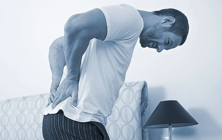 Hombre sujetándose la espalda baja por dolor lumbar