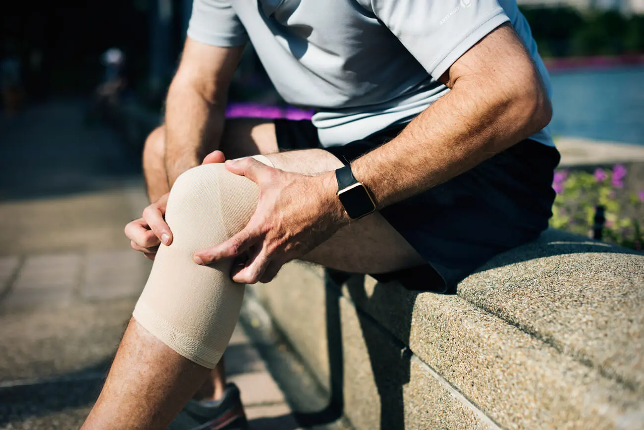 Persona sosteniéndose la rodilla con dolor